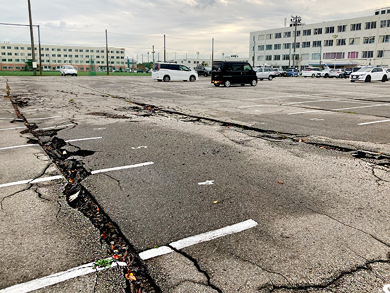 石川県が募集しているボランティアの宿泊拠点（ベースキャンプ）になっている「日本航空高校石川」の駐車場。地震の爪痕が残っている。