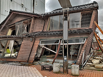 石川県輪島市街わいち通り。令和６年１月１日の大地震で傾いた家屋。公費解体が進んでいない。